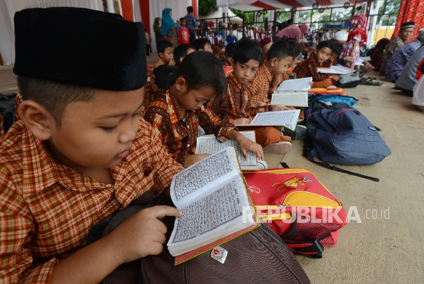 Sejumlah siswa SD 15 Cakranegara membaca Al Quran saat menonton MTQ di Islamic Center Kota Mataram, Nusa Tenggara Barat, Kamis (4/8)