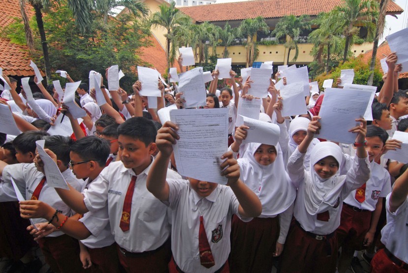 Sejumlah siswa SDN 4 Sukasari menunjukkan surat yang ditujukkan untuk Presiden Indonesia Joko Widodo, Tangerang, Banten, Selasa (29/3).