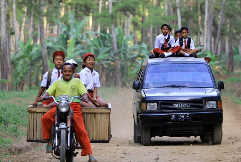 Sejumlah siswa sekolah dasar berangkat ke sekolah menaiki mobil angkut dan motor di Jayengan, Banyuwangi, Jawa Timur. (ilustrasi) 