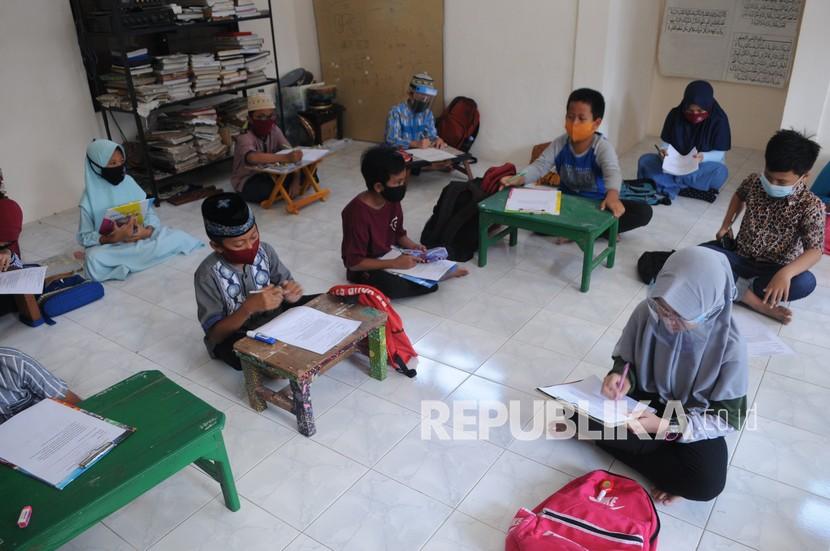 Sejumlah siswa sekolah dasar mengerjakan ulangan harian di rumah warga saat pembelajaran tatap muka di Pamekasan, Jawa Timur, Senin (14/9). (ilustrasi)