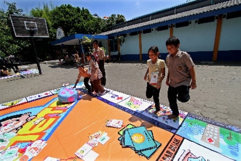 Sejumlah siswa SD Budi Mulia Dua bermain permainan monopoli raksasa di sekolahnya di Seturan, Sleman, Yogyakarta. Pembelajaran siswa didik melalui permainan luar ruang yang memerlukan banyak gerakan bertujuan mengatasi obesitas dini.