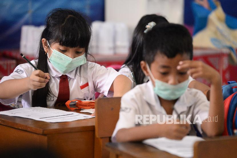 Sejumlah siswa-siswi kelas 3 SDN Depok Jaya 1, Kota Depok, Jawa Barat mengikuti kegiatan belajar mengajar dengan memakai masker wajah, Selasa (3/3). 