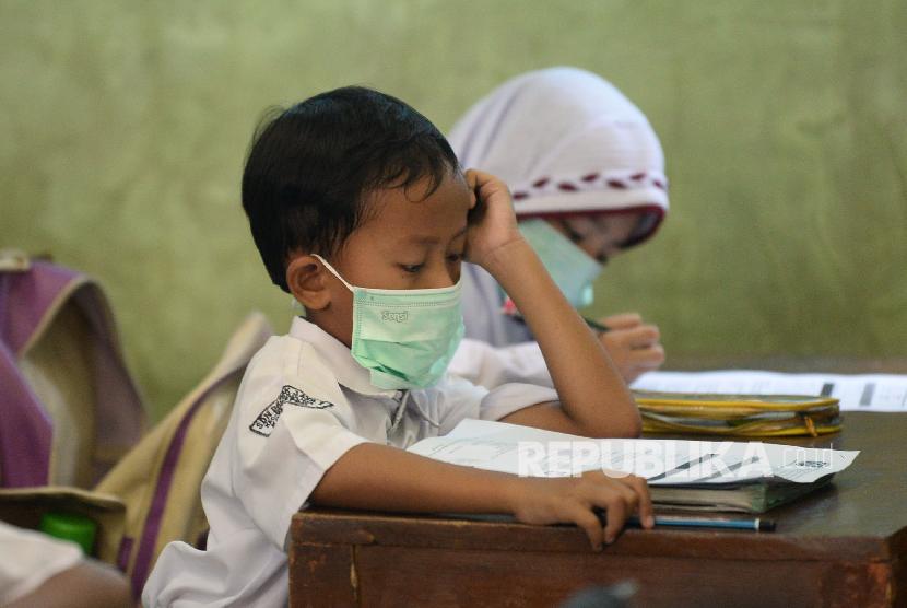 Sejumlah siswa-siswi kelas 3 SDN Depok Jaya 1, Kota Depok, Jawa Barat mengikuti kegiatan belajar mengajar dengan memakai masker wajah, Selasa (3/3). (Prayogi/Republika)