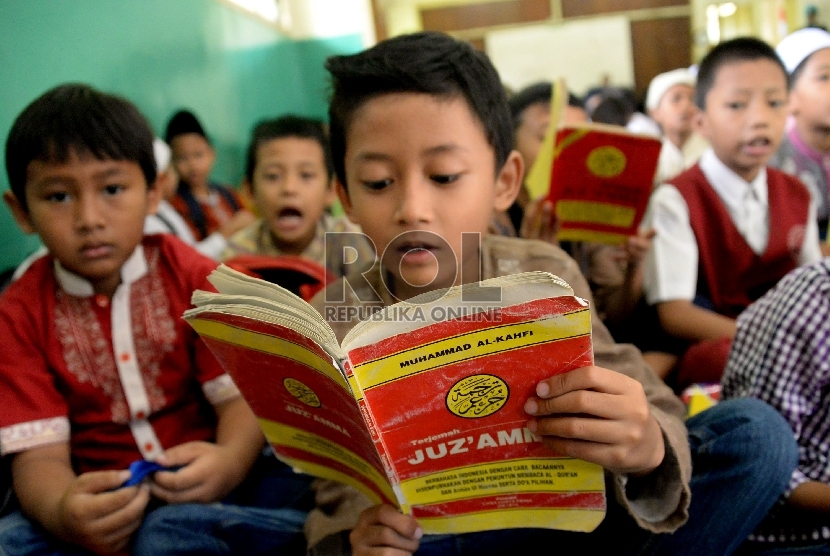 Sejumlah siswa-siswi membaca Juz Amma saat mengikuti kegiatan pesantren kilat Ramadhan di SDN Menteng Atas 02 Pagi, Jakarta, Selasa (23/6). 