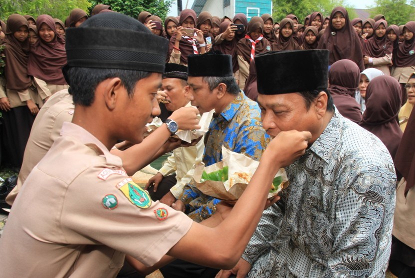 Sejumlah siswa-siswi menyuapkan nasi kepada guru saat peringatan Hari Guru Nasional (HGN) di Madrasah Tsanawiyah Negeri (MTsN) 3 Aceh Barat, Aceh, Sabtu (24/11/2018). 