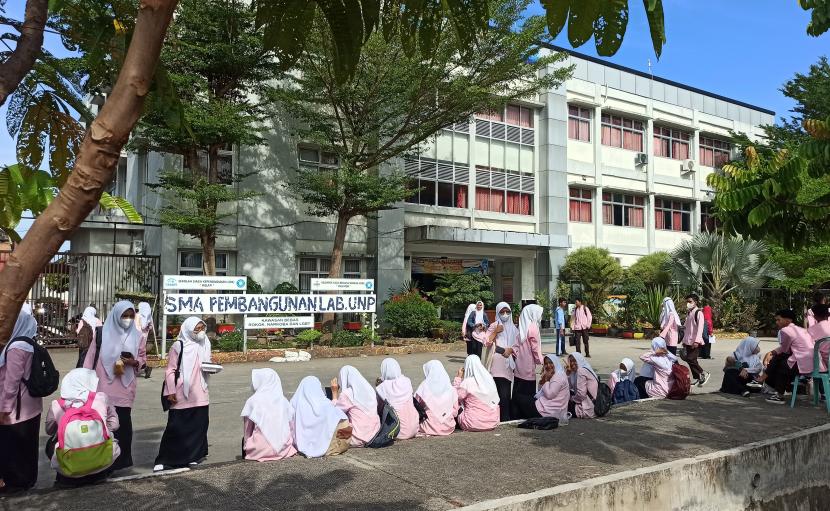 Sejumlah siswa SMA duduk di luar gedung sekolah dan bersiap pulang akibat gempa di Padang, Sumatera Barat, Jumat (25/2/2022). Sejumlah sekolah di Padang memulangkan siswanya akibat gempa bumi bermagnitudo 6,2 SR yang mengguncang wilayah Sumatera Barat tepatnya 17 km timur laut Pasaman Barat pada Jumat pukul 08.39 WIB.