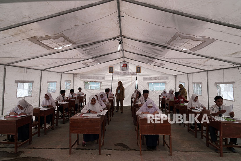 Sejumlah siswa SMP korban gempa bumi, mengikuti Ujian Nasional Kertas dan Pensil (UNKP) di tenda darurat milik Kemendikbud, di SMP N 2 Kalibening, Banjarnegara, Jawa Tengah, Senin (23/4).