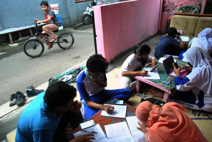 Sejumlah siswa SMP Kota Bogor mengerjakan tugas sekolah secara daring di rumah Ketua RT 03/10 Gang Kelor, Kelurahan Menteng, Kota Bogor, Jawa Barat, Kamis (13/8/2020). Warga RW 10 di lingkungan tersebut menggalang Gerakan Berbagi Internet atau Wifi dengan menyetorkan minyak jelantah, sampah anorganik dan bibit pohon kelor sebagai upaya membantu siswa dalam pembelajaran daring yang terkendala kuota dan jaringan internet.