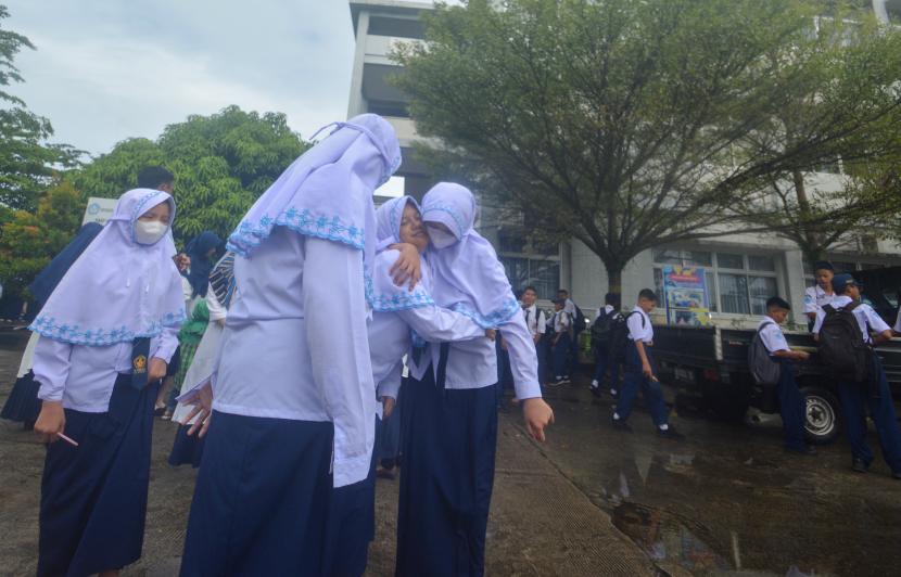 Sejumlah siswa SMP Pembangunan Laboratorium UNP berada di luar bangunan usai terjadi gempa di Padang, Sumatera Barat, Senin (29/8/2022). BMKG mencatat gempa berkekuatan 6,4 magnitudo pada Senin, (29/8/2022) pukul 10.29 WIB mengguncang 161 kilometer barat laut Kabupaten Kepulauan Mentawai yang terasa hingga ke Kota Padang. 