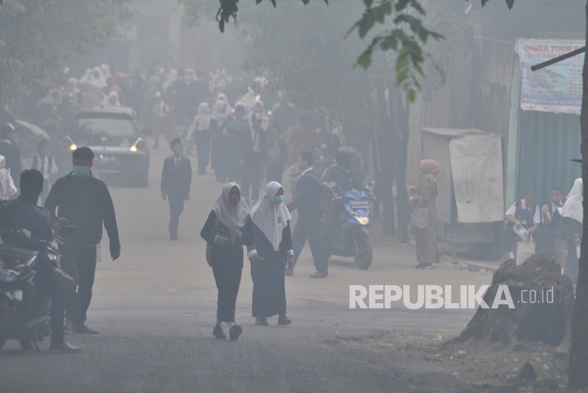 Sejumlah siswa SMP pulang lebih awal usai diumumkannya libur terkait kondisi kabut asap yang pekat di Palembang, Sumatera Selatan, Senin (14/10/2019). 