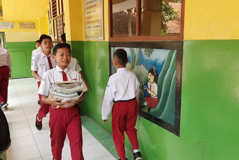 Sejumlah siswa SMPN 57 Kota Bekasi sedang mengangkat buku bekas SDN 10 ke ruangan kepala sekolah. SMPN yang baru dibuka sepekan yang lalu itu menempati gedung bekas SDN tersebut. 