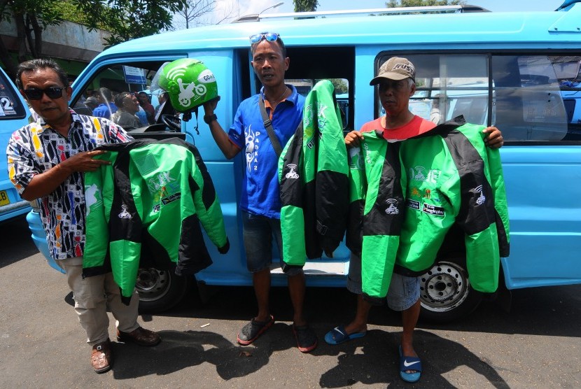 Sejumlah sopir angkutan kota Salatiga menunjukkan jaket hasil sitaan atribut pengendara transportasi daring atau online di Salatiga, Jawa Tengah, Senin (4/9). 