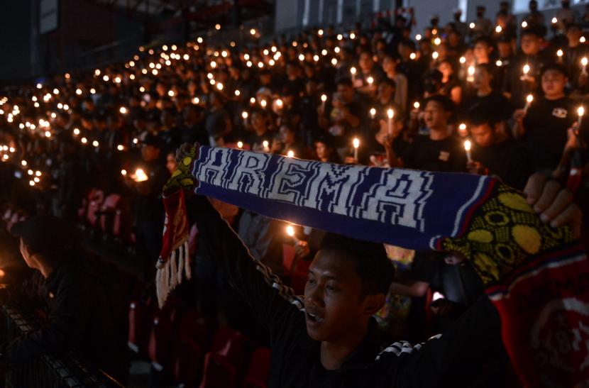Sejumlah suporter sepak bola menyalakan lilin saat mengikuti doa bersama bagi korban Tragedi Kanjuruhan, Kepanjen, Kabupaten Malang, Jawa Timur.