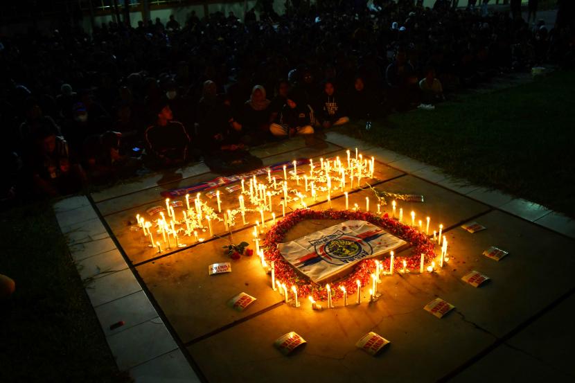 Sejumlah suporter sepak bola menyalakan lilin saat mengikuti doa bersama di kawasan Stadion Wilis Kota Madiun, Jawa Timur, Selasa (4/10/2022). Ribuan suporter sepak bola dari Madiun dan sekitarnya menggelar doa bersama untuk para korban tragedi di Stadion Kanjuruhan, Malang. 