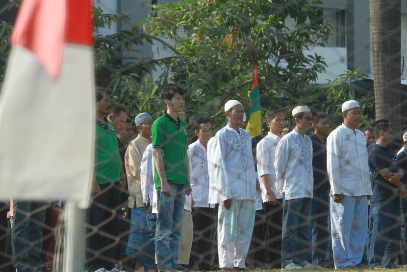 Sejumlah tahanan yang menerima remisi mengikuti upacara HUT ke-70 RI di Lapas Cipinang, Jakarta, Senin (17/8).