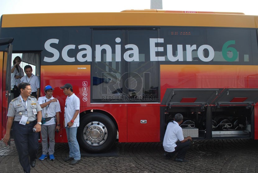   Sejumlah tamu undangan melihat bagian mesin Bus Scania Euro 6 saat melakukan uji coba melintas di Jalan Jendral Sudirman, Jakarta Pusat, Kamis (8/5). (Republika/Rakhmawaty La'lang)
