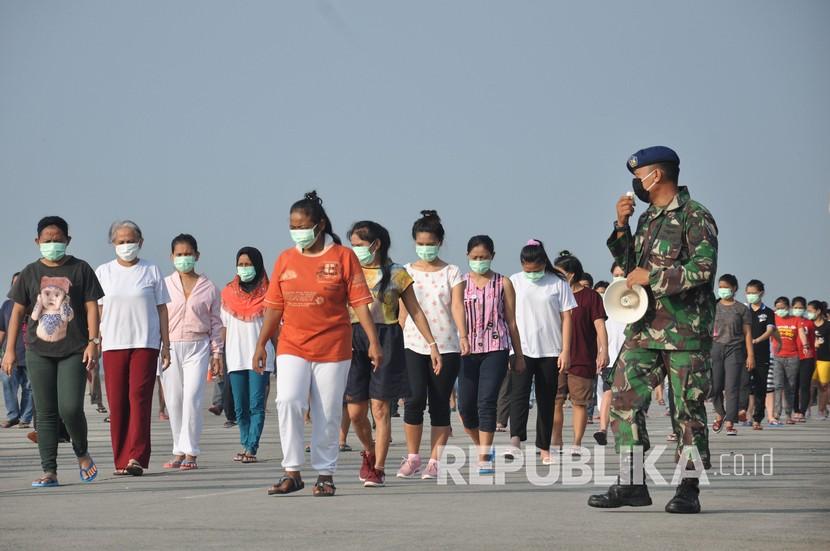 Sejumlah Tenaga Kerja Indonesia (TKI) asal Malaysia mengikuti senam dan berjemur di bawah sinar matahari saat menjalani karantina di Pangkalan Udara Militer (Lanud) Soewondo Medan, Sumatera Utara, Sabtu (11/4/2020). Sebanyak 513 TKI yang berasal dari berbagai daerah di Sumut dan sekitarnya yang menjalani proses karantina COVID-19 sementara tersebut saat ini kondisi kesehatannya baik dan tidak ada menunjukan gejala infeksi seperti demam, batuk dan sesak nafas.