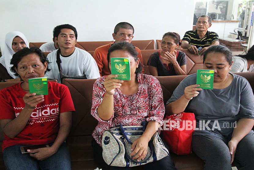 Sejumlah tenaga kerja Indonesia (TKI) yang dideportasi dari Malaysia memperlihatkan Surat Perjalanan Laksana Paspor di ruang ketibaan Pelabuhan Pelindo I Dumai, Dumai, Riau, Selasa (12/6).