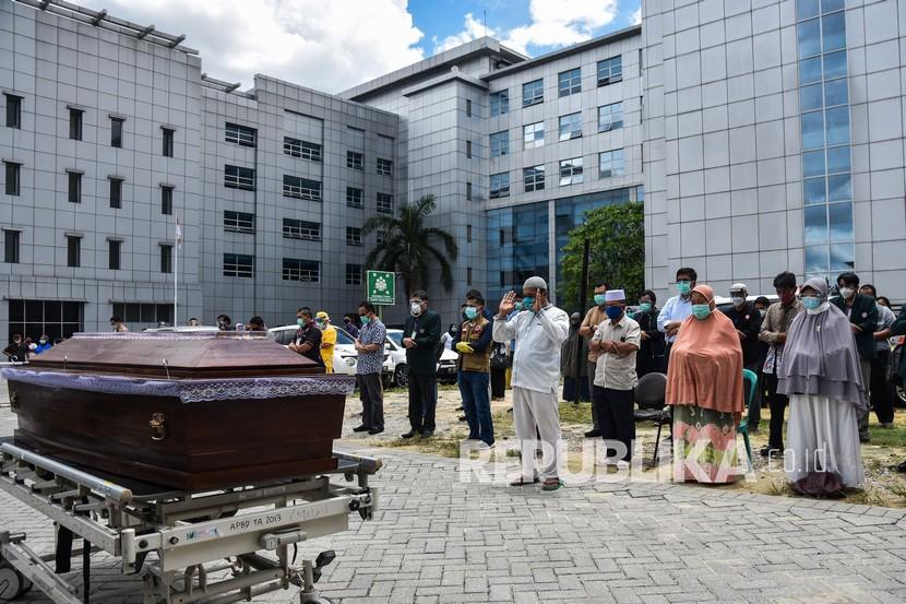 Sejumlah tenaga kesehatan, pelayat, dan keluarga melakukan shalat jenazah untuk dr Oki Alfin yang sudah ditempatkan di peti mati setelah meninggal akibat Covid-19, di halaman RSUD Arifin Achmad, Kota Pekanbaru, Riau, Sabtu (12/9/2020). Sampai Jumat (18/9) sudah 117 dokter wafat akibat Covid-19.