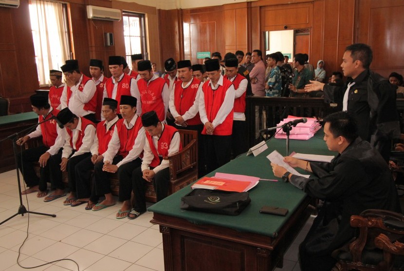  Sejumlah terdakwa kasus dugaan pembunuhan dan pengeroyokan aktivis lingkungan Salim Kancil mengikuti sidang di Pengadilan Negeri (PN) Surabaya, Jawa Timur, Kamis (10/3). 