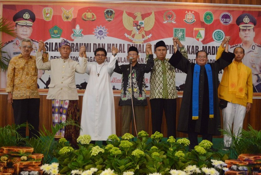 Sejumlah tokoh agama saling bergandengan tangan saat pembacaan pernyataan sikap terkait kasus Tolikara, Papua, seusai menghadiri halal bihalal di Mapolres Madiun, Jawa Timur, Jumat (24/7). 