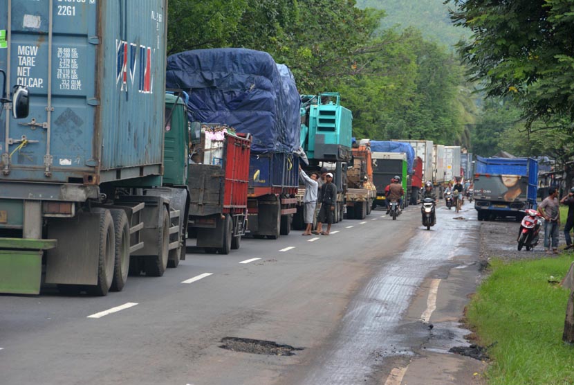 Sejumlah truk terjebak macet di jalan raya Pantura Dusun Pecaron, Kendit, Situbondo, Jawa Timur, Sabtu (1/2).