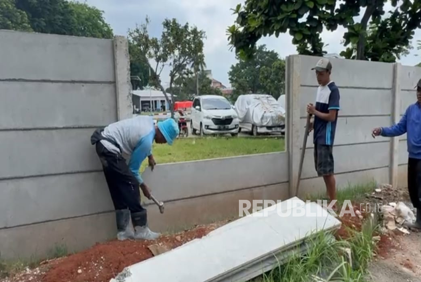 Sejumlah tukang melakukan pembongkaran pagar di kawasan Asrama Haji Pondok Gede Jakarta, Senin (13/10/2025).