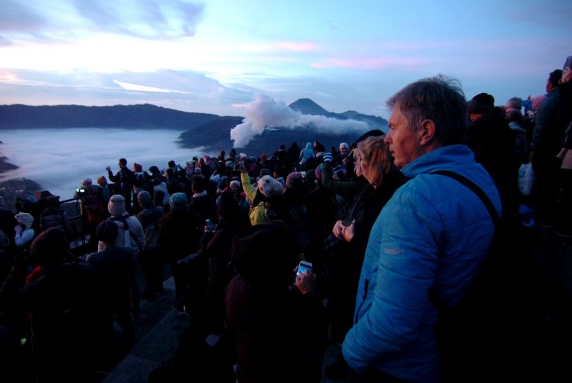 Sejumlah turis mancanegara menikmati pemandangan matahari terbit saat berkunjung ke Taman Nasional Bromo Tengger, Desa Wonokitri, Kabupaten Pasuruan. Jawa Timur, Kamis (8/11). 