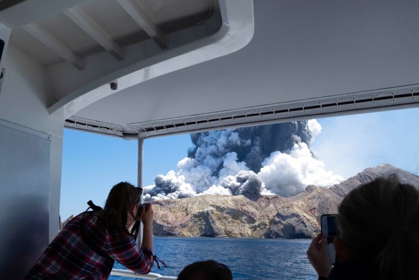 Sejumlah turis mengabadikan erupsi gunung berapi di White Island, Selandia Baru, Senin (9/12).