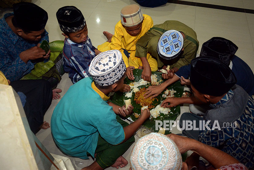 Sejumlah umat Islam berbuka puasa bersama dalam tradisi megibung di Masjid Al Muhajirin, Kepaon, Denpasar, Bali, Sabtu (26/5). 