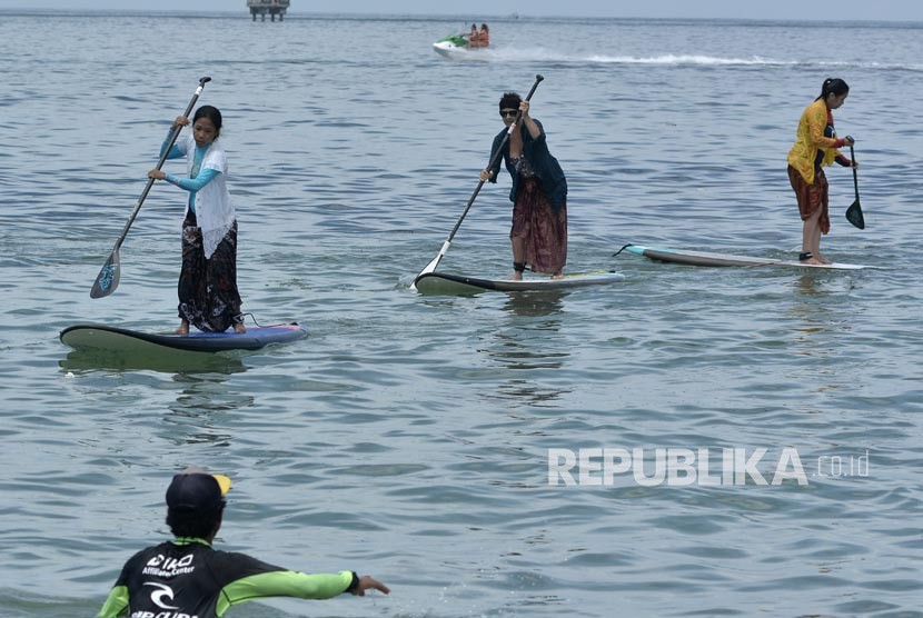 Sejumlah wanita dan wisatawan mancanegara mengenakan kebaya mendayung paddle board di kawasan Pantai Sanur, Bali (ilustrasi)