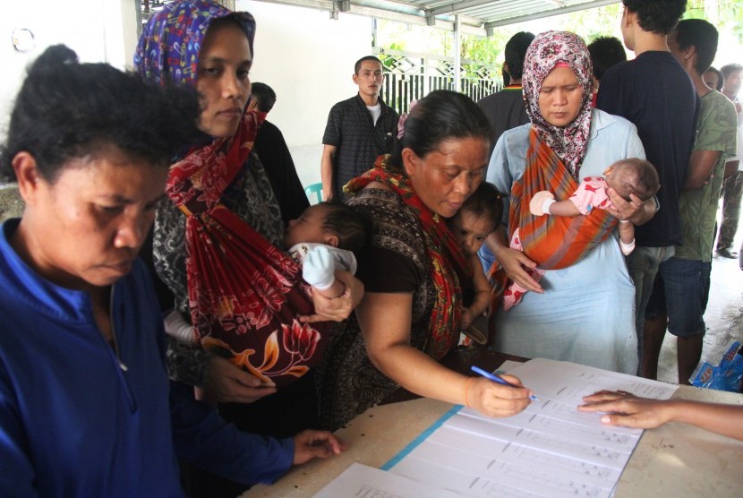 Sejumlah wanita pekerja migran ilegal menggendong anaknya yang masih balita saat mengisi formulir data di Pos Perlindungan Tenaga Kerja Indonesia di kota Dumai, Riau. ilustrasi