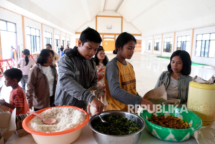 Sejumlah warga antre mengambil makanan di posko pengungsian Tongkonan Toraja, Kota Wamena, Kabupaten Jayawijaya, Papua, Sabtu (12/10/2019). 