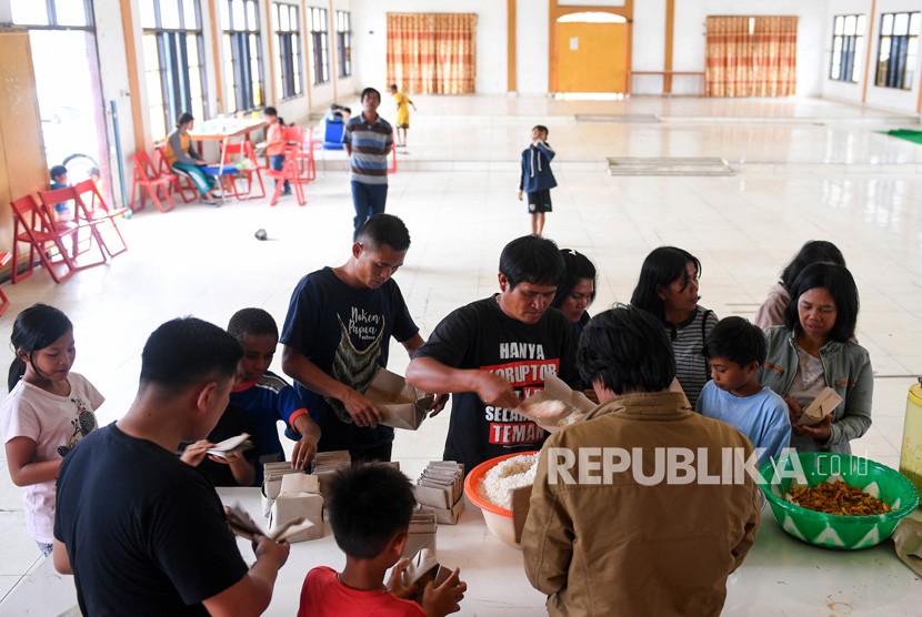 Sejumlah warga antre mengambil makanan di posko pengungsian Tongkonan Toraja, Kota Wamena, Kabupaten Jayawijaya, Papua, Sabtu (12/10/2019). 