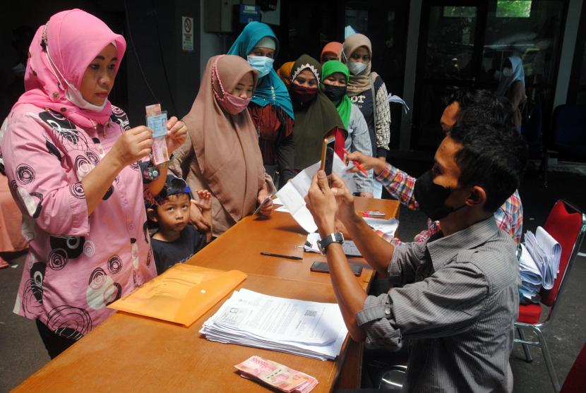 Sejumlah warga antre saat penyaluran BLT subsidi minyak goreng di Kecamatan Bogor Timur, Kota Bogor, Jawa Barat, Kamis (14/4/2022).