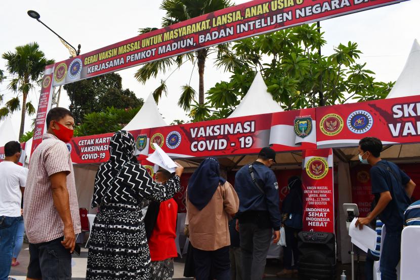 Sejumlah warga antre untuk mendapatkan suntikan vaksin COVID-19 saat digelar Vaksinasi COVID-19 massal di ruang publik kawasan Sumber Wangi, Kota Madiun, Jawa Timur, Senin (14/2/2022). Badan Intelijen Negara (BIN) berkolaborasi dengan Pemkot Madiun dan Federasi Serikat Pekerja Pertamina Bersatu (FSPPB) menggelar vaksinasi massal guna mendukung terciptanya kekebalan kelompok dengan target 14 hari sebanyak 12.250 dosis vaksin pertama, kedua dan penguat (booster).