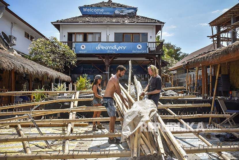 Sejumlah warga asing membersihkan puing-puing atap restorannya yang runtuh pasca gempa bumi di kawasan wisata Gili Trawangan, Lombok Utara, NTB, Rabu (8/8). Sejumlah fasilitas publik untuk wisatawan seperti restoran, hotel, jeti pelabuhan dan jaringan listrik rusak terdampak akibat gempa. 