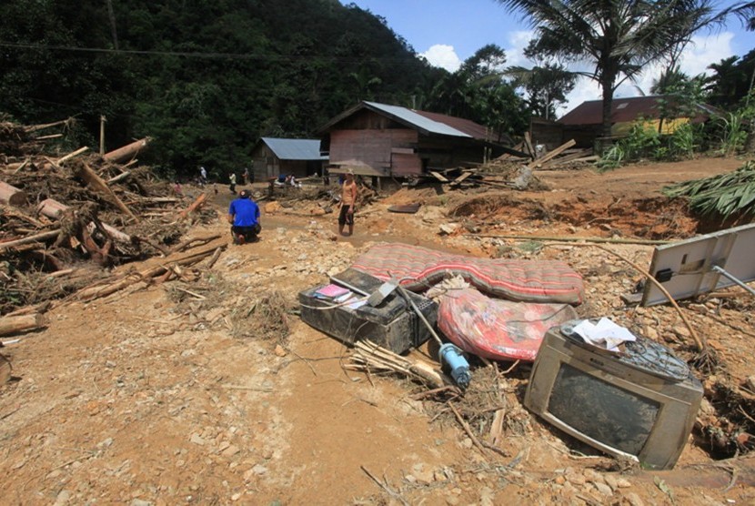 Sejumlah warga berada di antara material lumpur dan kayu yang terbawa arus banjir bandang  (ilustrasi)