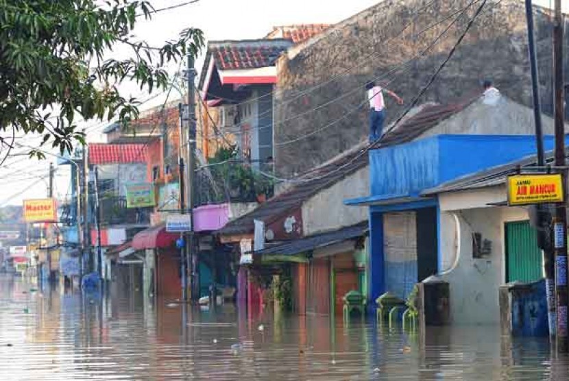 Sejumlah warga berada di atas atap rumah akibat banjir di kawasan Pondok Gede Permai, Jatiasih, Bekasi Selatan, Bekasi, Jabar, Selasa (5/2).