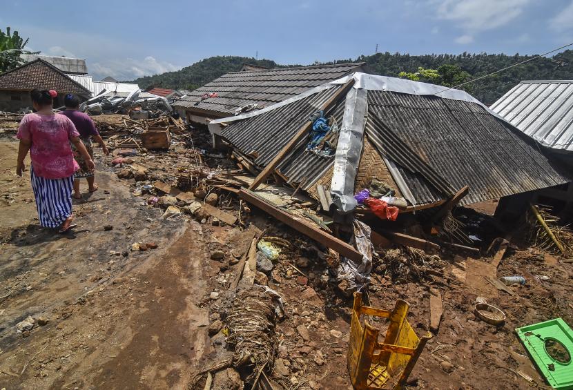 Sejumlah warga berada di dekat rumah yang tertimbun tanah akibat longsor di Dusun Kekait Daye, Desa Kekait, Kecamatan Gunungsari, Lombok Barat, NTB, Rabu (8/12/2021). Longsor disertai banjir bandang yang terjadi di daerah tersebut pada Senin (6/12/2021) mengakibatkan sebanyak 37 rumah warga rusak berat dan 300 jiwa mengungsi.A
