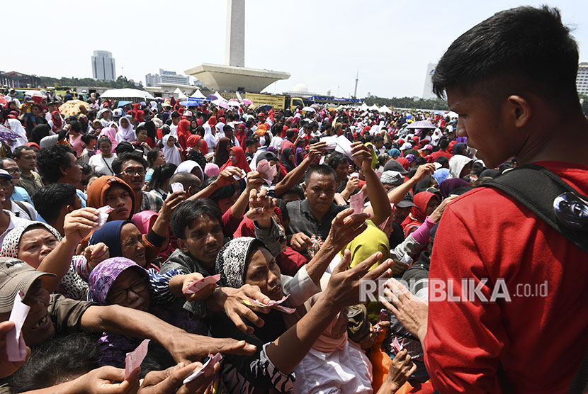 [Ilustrasi] Sejumlah warga berdesakan untuk mengambil sembako gratis saat acara Untukmu Indonesia di Monas, Jakarta, Sabtu (28/4). 