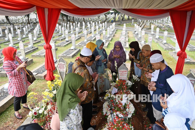 Sejumlah warga berdoa saat berziarah di makam BJ Habibie dan istrinya, Hasri Ainun Habibie di Taman Makam Pahlawan Nasional Utama (TMPNU) Kalibata, Jakarta Selatan, Jumat (13/9/2019). 