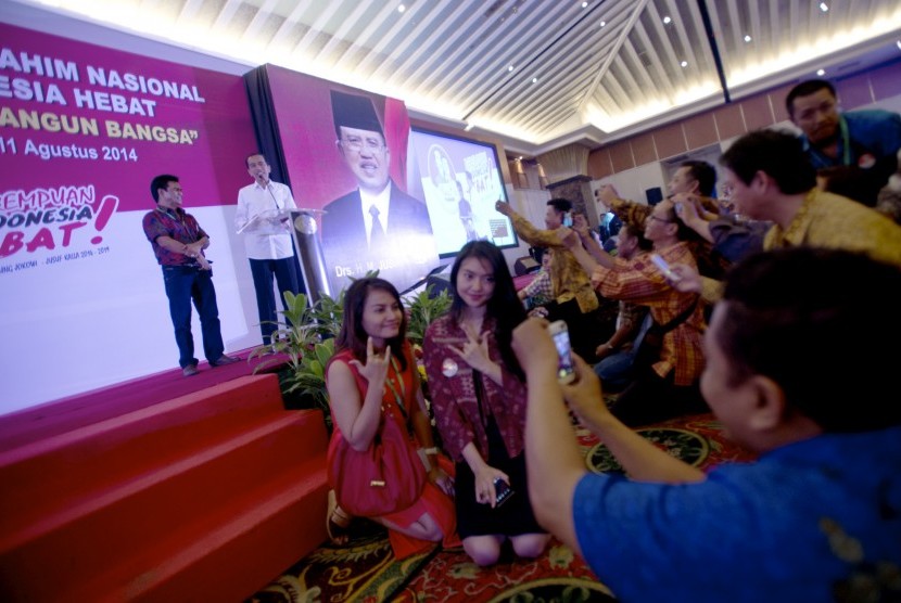 Sejumlah warga berfoto di sela-sela Presiden terpilih periode 2014-2019 Joko Widodo memberi sambutan dalam Musyawarah dan Silaturahmi Nasional Rumah Koalisi Indonesia Hebat di Jakarta, Senin (11/8) malam.