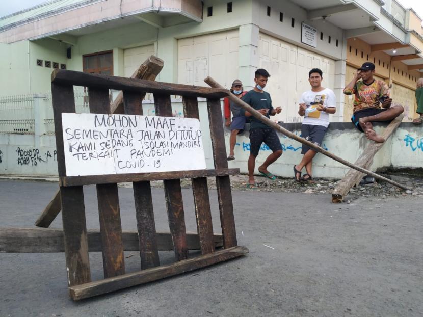 Sejumlah warga berjaga di akses jalan masuk ke Kampung Sambongpari Kidul, Kelurahan Sambongpari, Kecamatan Mangkubumi, Kota Tasikmalaya, Ahad (20/6). Akses ke kampung itu ditutup warga lantaran ada belasan orang yang terkonfirmasi positif Covid-19