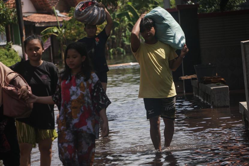 Sejumlah warga berjalan melewati jalan di sekitar rumahnya yang tergenang banjir rob di Pekalongan, Jawa Tengah (ilustrasi)