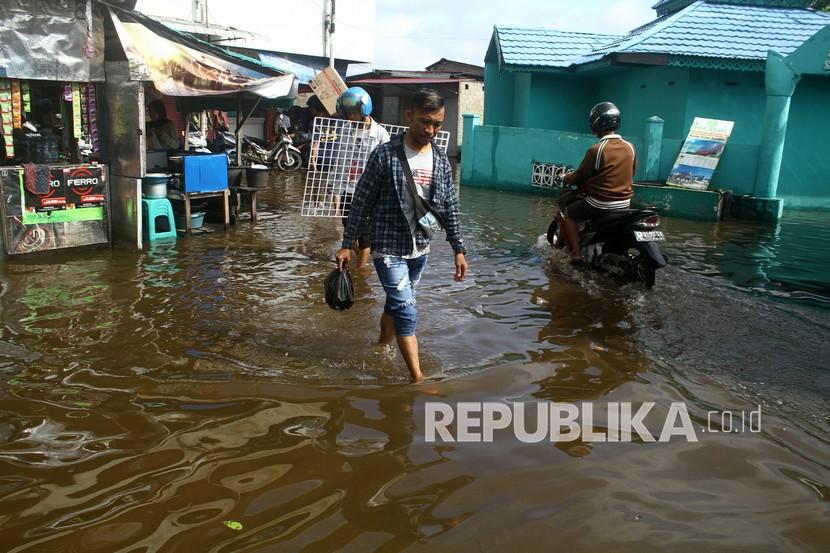 Sejumlah warga berjalan melintasi jalan yang terendam banjir rob di Pasar Kapuas Indah, Kalimantan Barat.  Badan Nasional Penanggulangan Bencana (BNPB) mengungkapkan banjir melanda 6 Kecamatan di Kabupaten Kapuas Hulu, Kalimantan Barat. Banjir dengan tinggi muka air antara 20 hingga 180 cm tersebut, terjadi pasca hujan dengan intensitas tinggi pada Kamis (4/8) sore hari hingga Jumat (5/8) yang mengguyur wilayah Kabupaten Kapuas Hulu. 