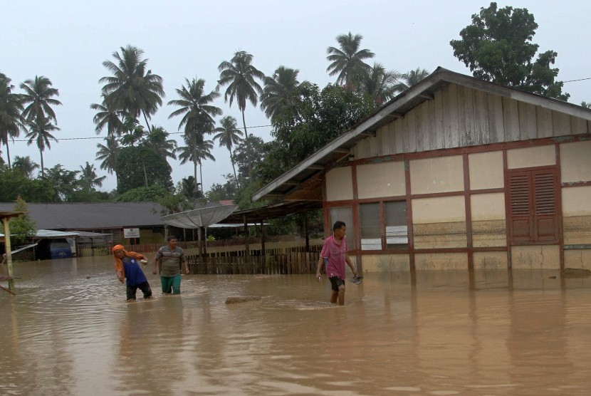 Sejumlah warga berjalan menembus banjir yang melanda kawasan Tarandam, Kecamatan Sungai Pagu, Kabupaten Solok Selatan, Sumatra Barat.