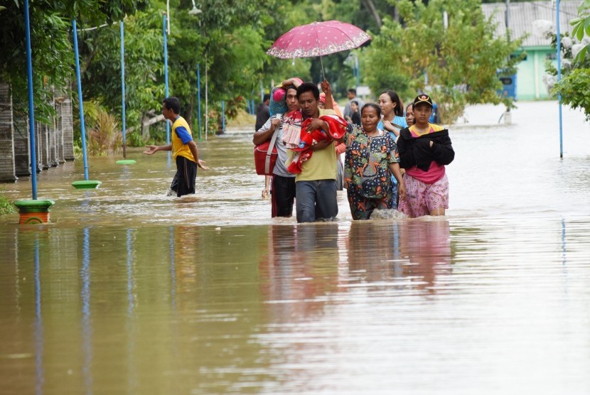 Sejumlah warga berjalan menerobos banjir untuk mengungsi di Desa Garon, Kecamatan Balerejo, Kabupaten Madiun, Jawa Timur, Kamis (7/3/2019). 