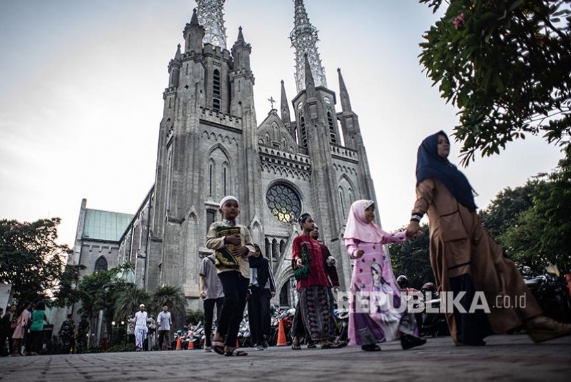 KWI Dukung Rencana Pembangunan Terowongan Istiqlal-Katedral. Sejumlah warga berjalan menuju Masjid Istiqlal seusai memarkir kendaraan bermotornya di Gereja Katedral, Jakarta.