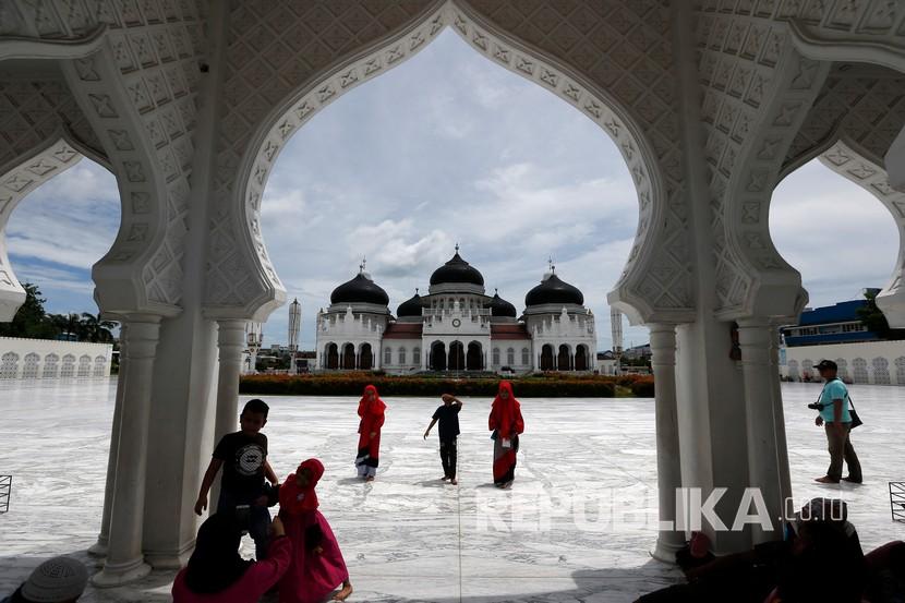 Sejumlah warga berkunjung ke Masjid Raya Baiturrahman, Banda Aceh, Aceh, Senin (25/5/2020). Masjid Raya Baiturrahman yang menjadi salah satu objek wisata religi pada libur Idul Fitri 1441 H ini terpantau sepi kunjungan bila dibandingkan tahun lalu akibat pandemi COVID-19. 